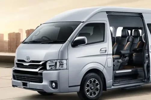 Toyota HiAce Luxury silver dengan pintu geser terbuka dan captain seat